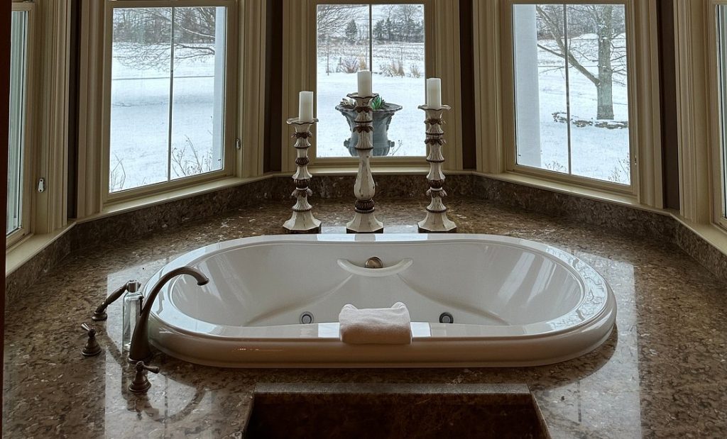 Corner jacuzzi tub positioned by large windows, overlooking a snowy landscape in a quiet hotel room